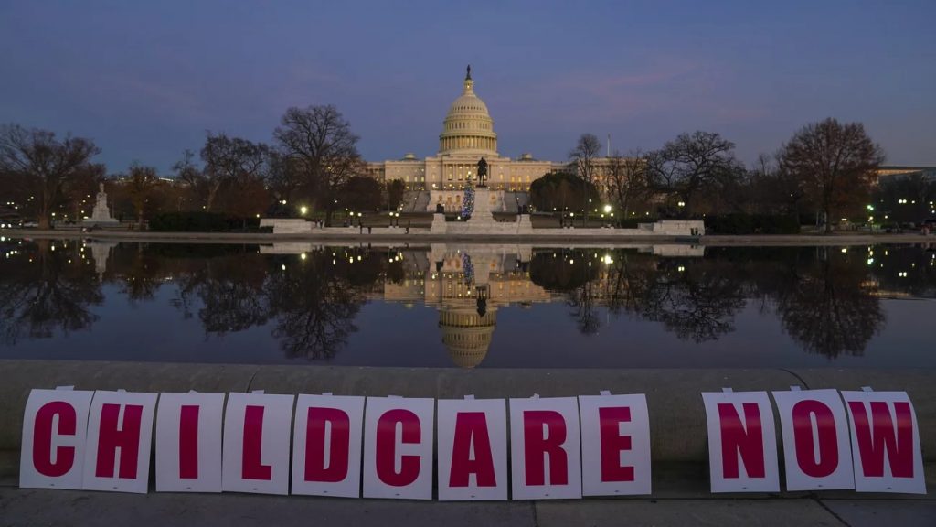 The U.S. Capitol building is in the background of the reflecting pool. A sign spells out childcare now in front of it. It's dusk.