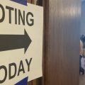 Poll workers wait for voters in Franklin County, Ohio behind a door that has a voting today sign taped to it