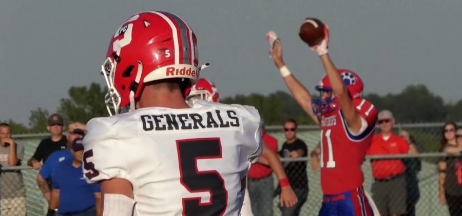 Sheridan DB stands in the foreground with a Licking Valley player celebrating in the background