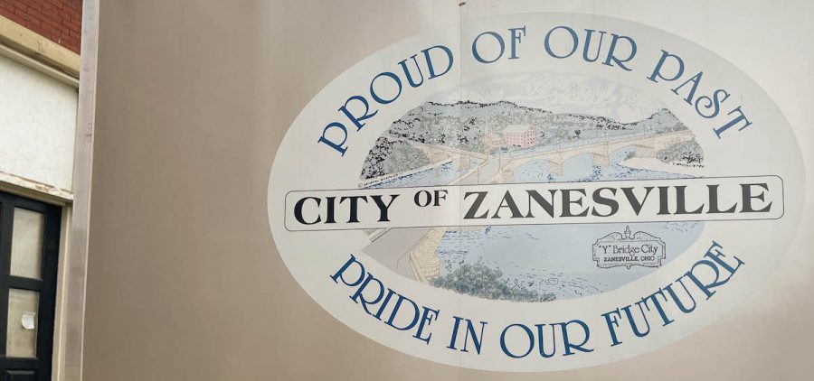 An image of a logo on a trailer during the 2022 Y-Bridge Festival in Zanesville. The logo reads: Proud of our past, City of Zanesville, pride in our future. There is an illustration of the Muskingum River in the center of the logo.