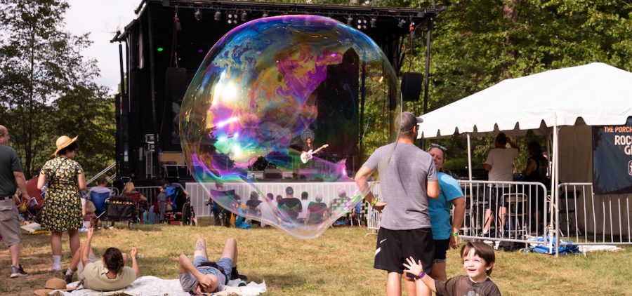 A child runs toward a bubble while no stars plays at Nelsonville Music Festival’s Porch Stage on Friday, September 2, 2022, in Nelsonville, Ohio.
