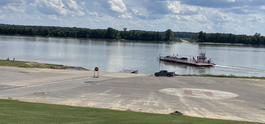 A red and white ferryboat makes its way in the middle of the Ohio River.