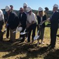 Officials shovel dirt at the groundbreaking ceremony for a new building at the Bill Theisen Industrial Park in The Plains.