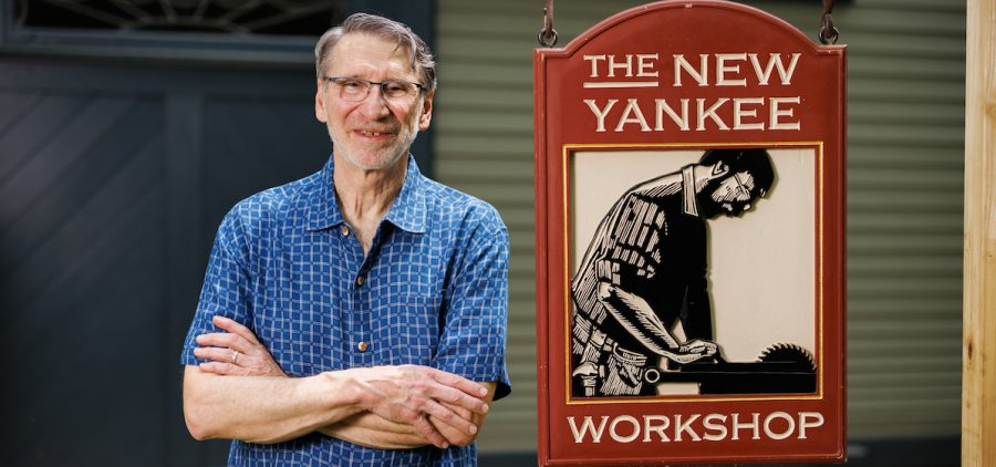 Norm Abram standing next to "New Yankee Workshop" sign