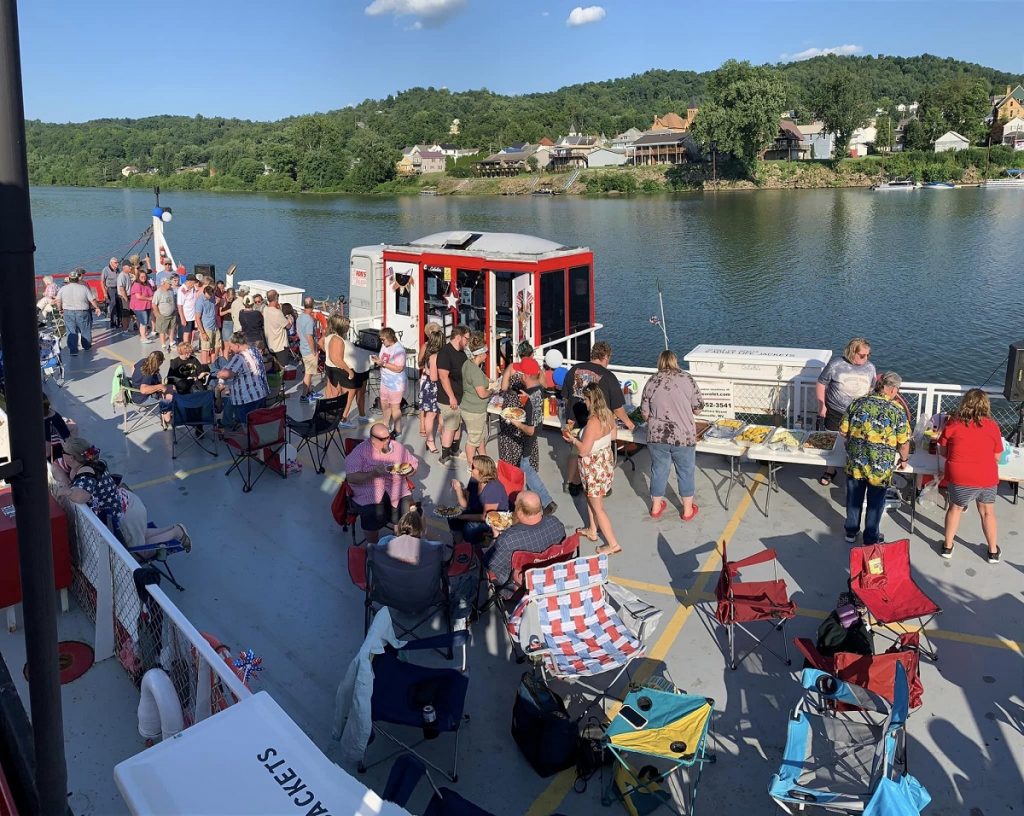 People line up for a buffet of food on the Sistersville ferry boat in the middle of the Ohio River.