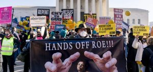 Stephen Parlato of Boulder, Colo., holds a sign that reads "Hands Off Roe!!!" as abortion rights advocates and anti-abortion protesters demonstrate in front of the U.S. Supreme Court, Wednesday, Dec. 1, 2021, in Washington.