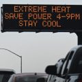 Vehicles drive past a sign on the 110 Freeway warning of extreme heat and urging energy conservation during a heat wave in downtown Los Angeles on Sept. 2.