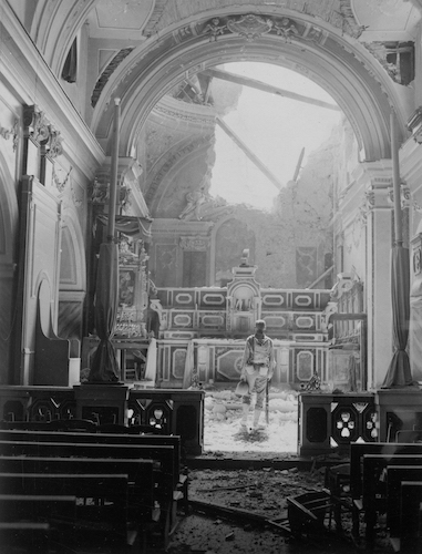 An army private stands before a damaged altar in Acerno, Italy, on September 23, 1943.