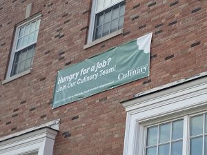 A sign outside Jefferson Market advertises for job openings in Culinary Services