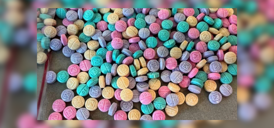 Colorful fentanyl pills that look like candy are lay out on a table