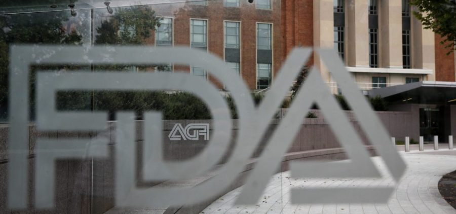 the U.S. Food and Drug Administration (FDA) building is visible behind FDA logos at a bus stop on the agency's campus in Silver Spring, Md.