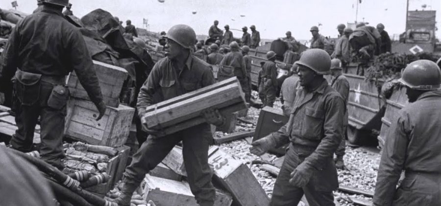 Three Black WWII soldiers unloading supplies on beach