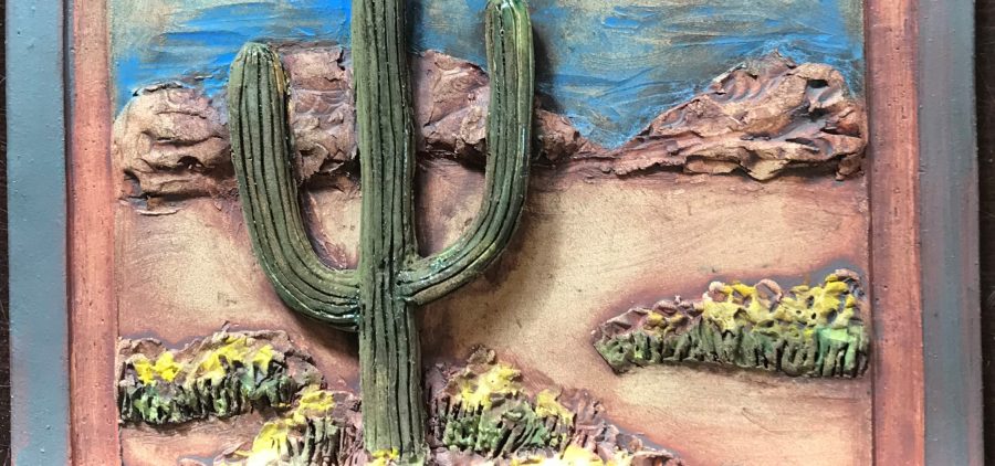 An image of a decortaive tile with a cactus on it.