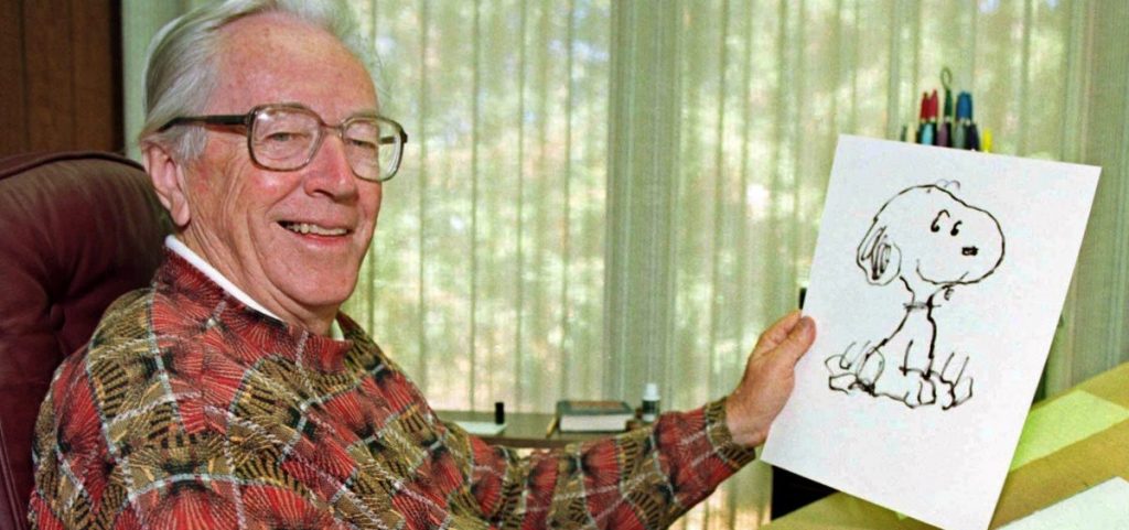 Charles Schulz holds up a sketch of Snoopy
