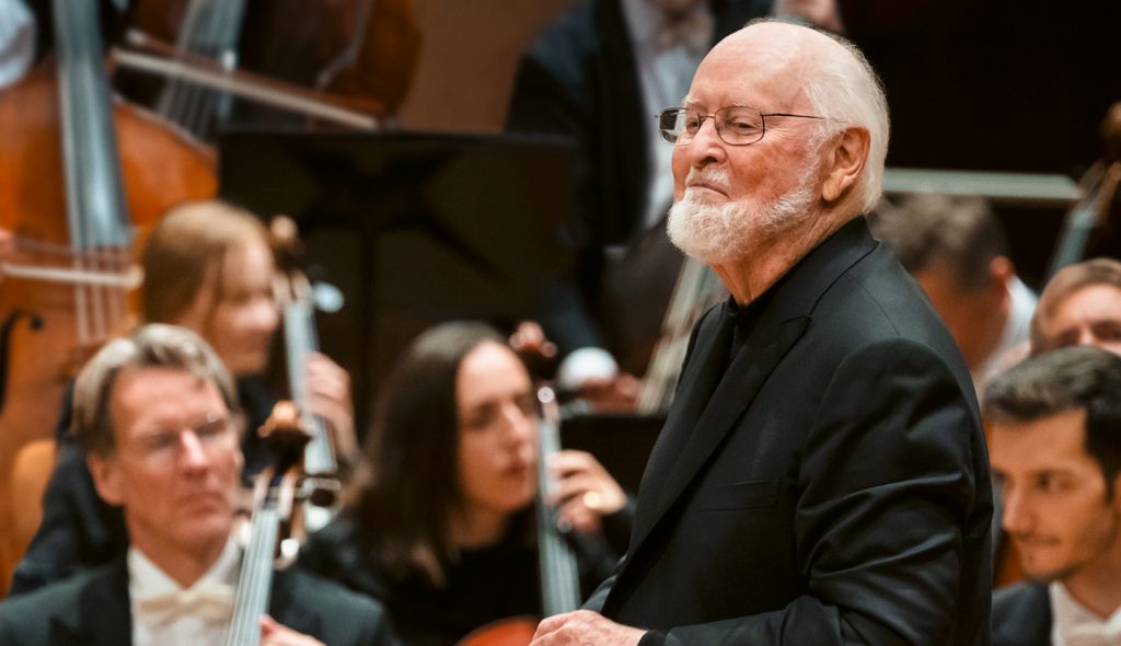 An image of conductor John Williams in front of an orchestra.