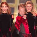 Four female Irish dancers with male pointing at camera