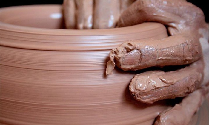 An image of hands on a pottery wheel.