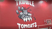The Trimble Tomcats gym wall with their mascot painted on it. 