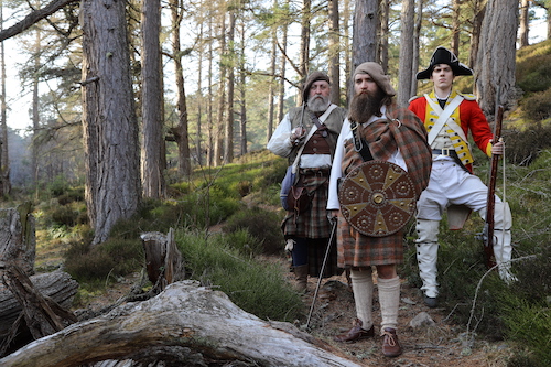 Scots in traditional outfits in forest