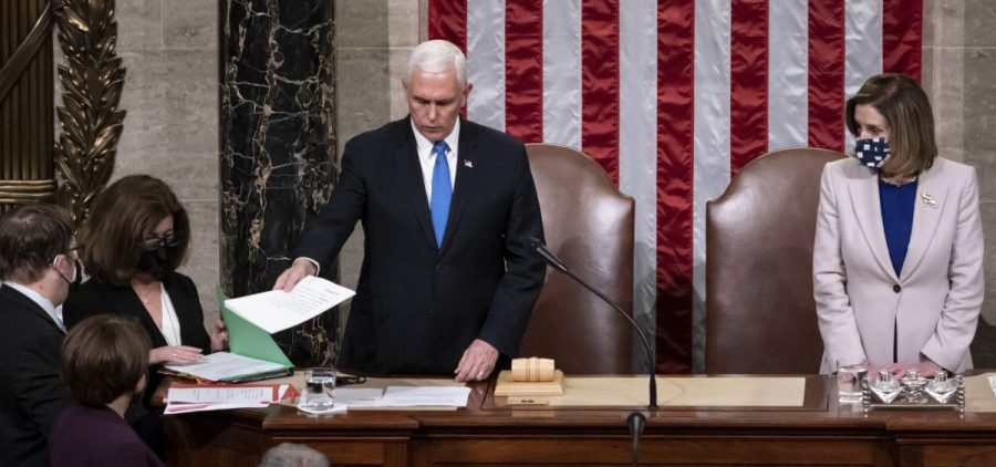 Vice President Mike Pence, left, and Speaker of the House Nancy Pelosi, D-Calif., return to the House chamber after midnight, Jan. 7, 2021, to finish the work of the Electoral College
