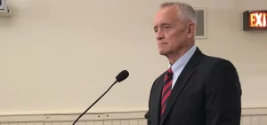 Joe Deters stands in front of a microphone