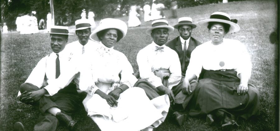 Photo portrait of African American family sitting on picnic grass in Sugarland, Maryland.