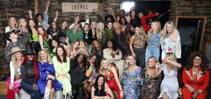 CMT’s Next Women of Country 2022 class, along with key alumni of NWOC’s 9 previous classes, pose with CMT Senior Vice President of Music Strategy, Leslie Fram, seated front and center at City Winery Nashville.
