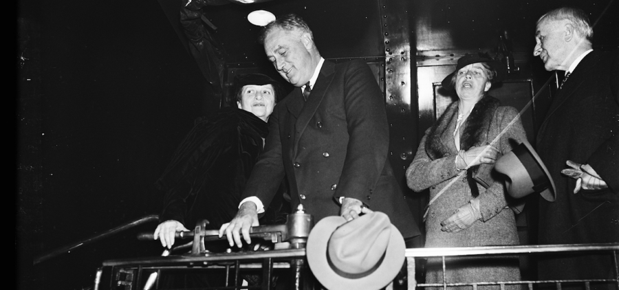 Frances Perkins with President Roosevelt and others on back of train