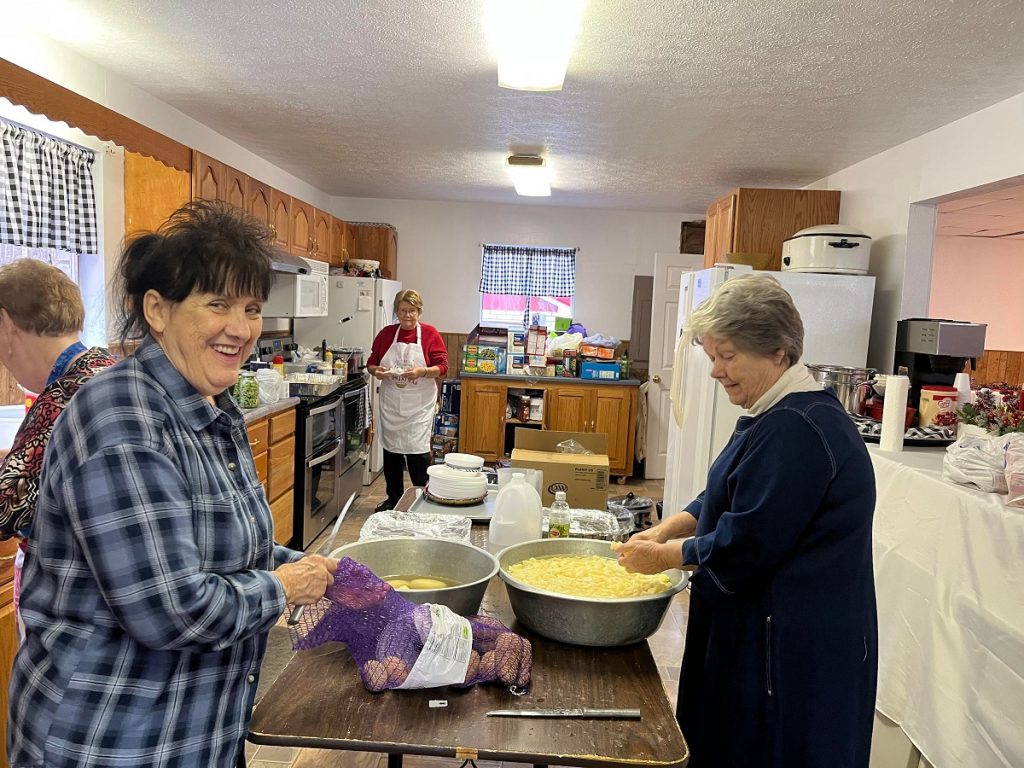 Church volunteers prepare Christmas dinner, the first since before COVID.