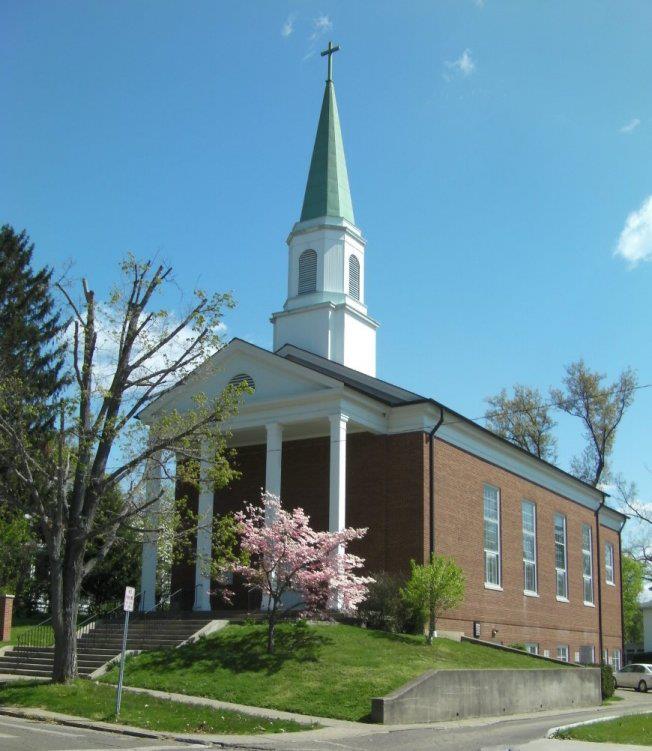 A picture of the Episcopal Church of the Good Shepherd in Athens, OH. The church is made of brick and is on a slight grassy incline.