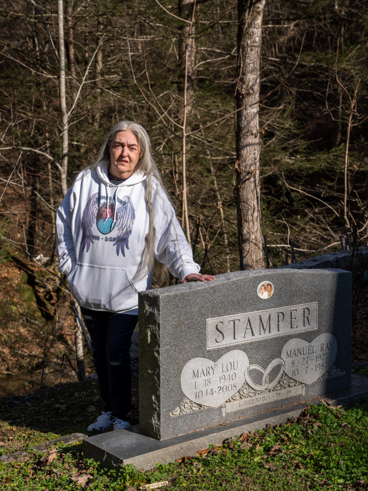 Janis Neace stands by her parents' graves, which are at risk of destabilization after flooding.