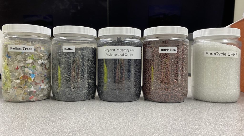 Jars full of plastics that can be turned into the clear pellets that are in the last jar on the right, labeled PureCycle UPRP.