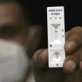 A man holds a negative rapid antigen coronavirus test at a makeshift testing center run by the Magen David Adom emergency service, in east Jerusalem