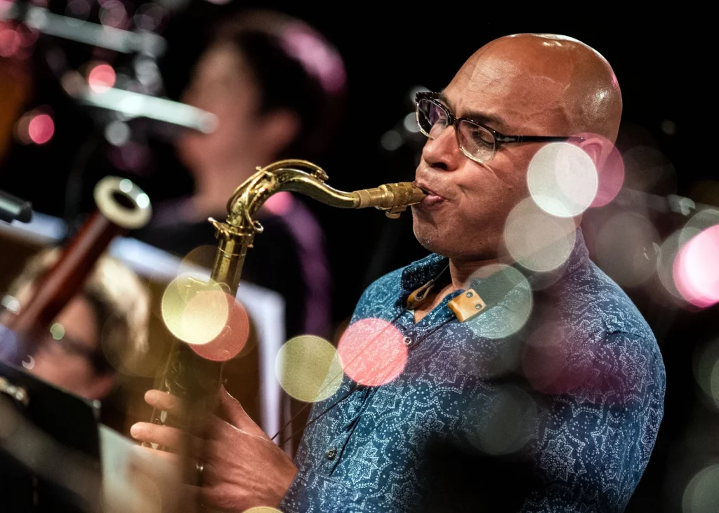 Jazz saxophonist Joshua Redman plays in 2019. He is wearing glasses.