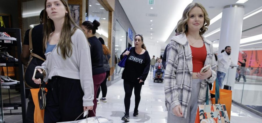 Women carry shopping bags as customers visit the American Mall dream mall during Black Friday