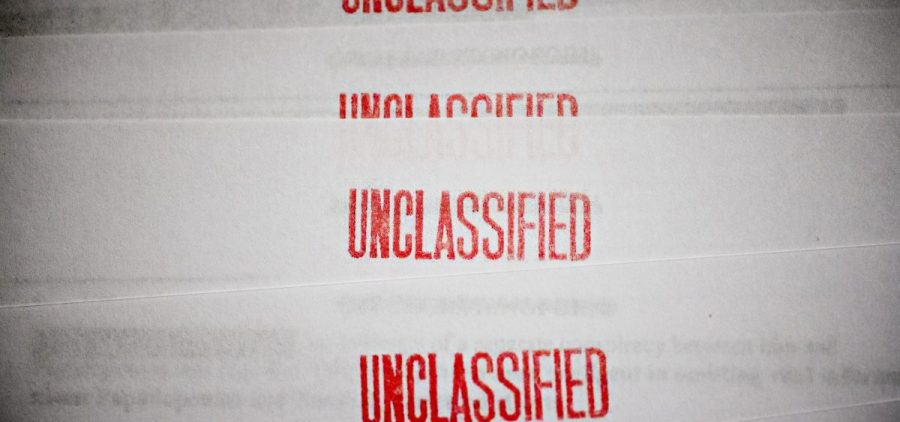 Pieces of paper with UNCLASSIFIED written in red on the top
