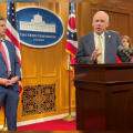Senate President Matt Huffman, center, speaks at a podium in reaction to the State of the State address from Gov. Mike DeWine. He is flanked by Sen Matt Dolan, left, and Sen. Theresa Gavarone, right, in the Ohio Statehouse press briefing room.