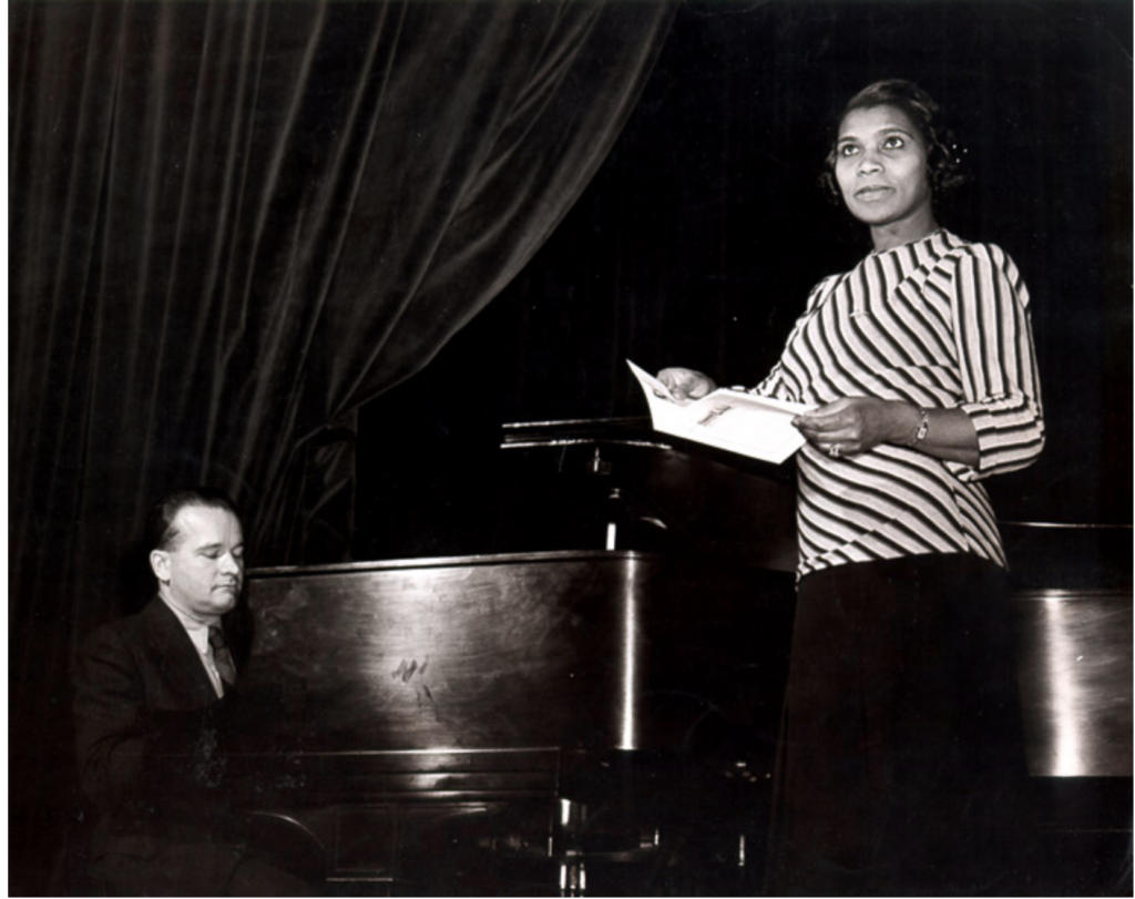 An image of Marian Anderson performing in front of a piano.