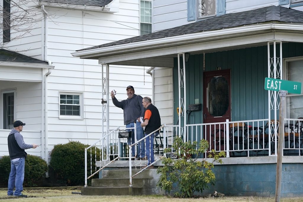Neighbors gather outside a home in East Palestine on Thursday, Feb. 9, 2023 as residents were allowed back in their homes after a derailment of a Norfolk Southern freight train Friday night forced their evacuation. (AP Photo/Gene J. Puskar)