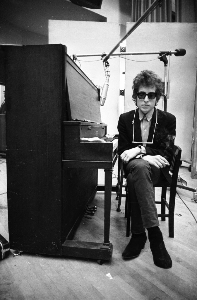 An image of Bob Dylan sitting in a chair.