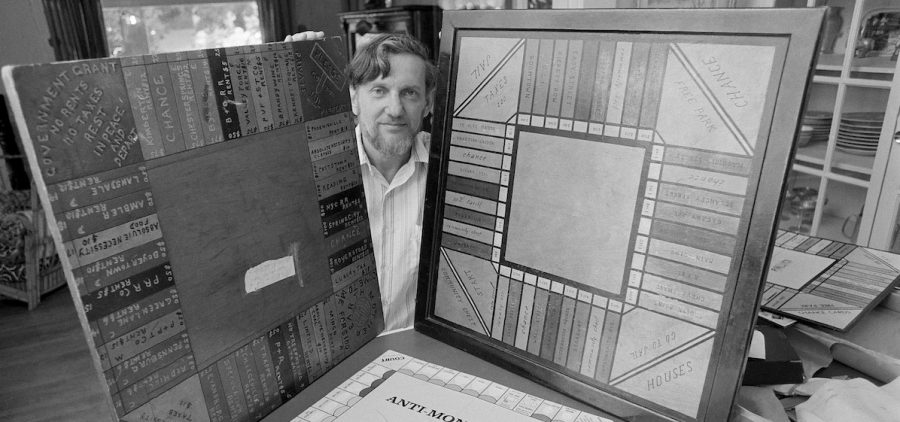 inventor of the game "Monopoly" holding two homemade boards