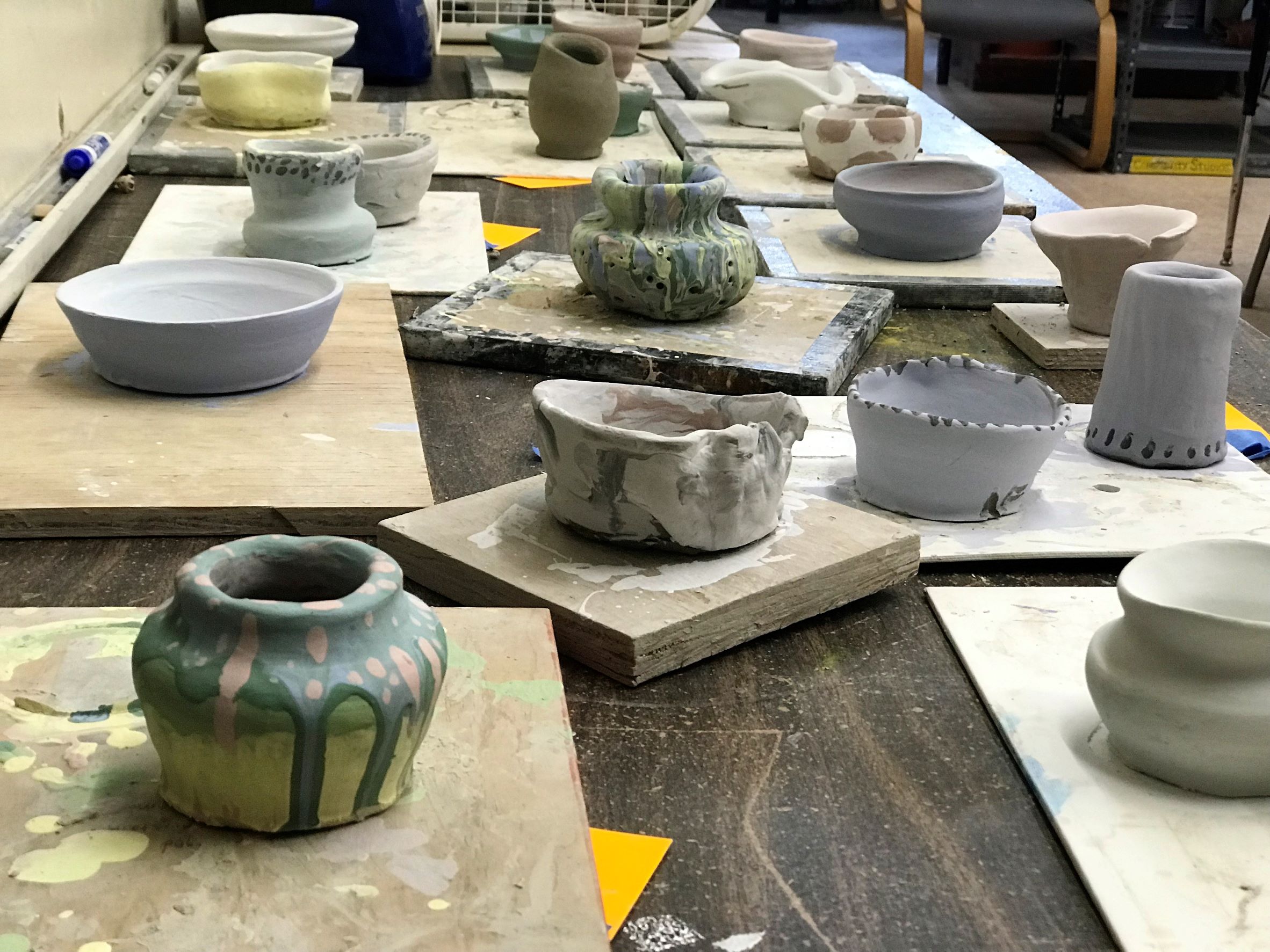 An image of pottery in various stages of completion.