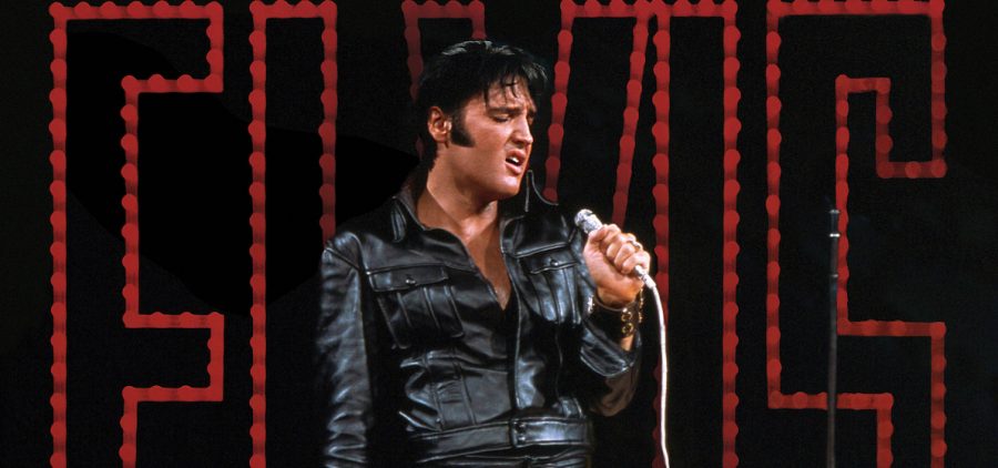 Elvis Presley on stage in front of large ELVIS neon sign