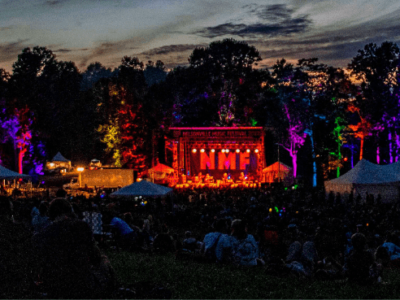 An image of the Nelsonville Music Festival stage, which is outside in the twilight.