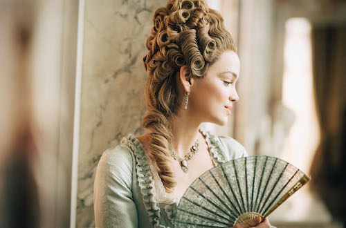 actress playing MARIE ANTOINETTE holding cloth fan