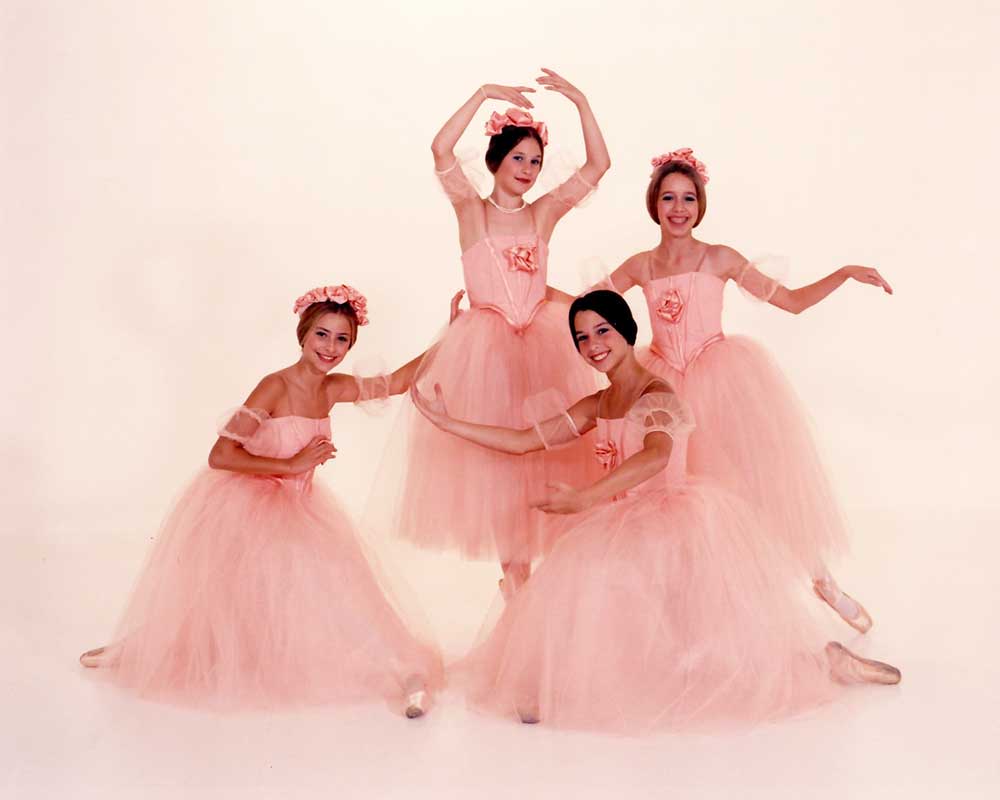 A picture of young ballerinas dressed in pink ballet outfits against a white background.