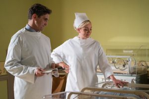 Dr. & Nurse in white scrubs looking over baby nursery