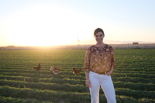 host posing in a Mennonite field in Sabinal, Mexico, a few chickens in the field