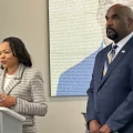 Kristen Clarke, Assistant Atty General, Dept of Justice, Civil Rights Division stands next to U.S. Attorney at a press conference.
