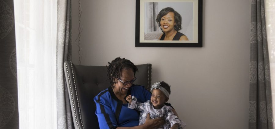 Wanda Irving holds her granddaughter, Soleil, in front of a portrait of Soleil's mother, Shalon Irving, at her home in Sandy Springs, Ga., in 2017.